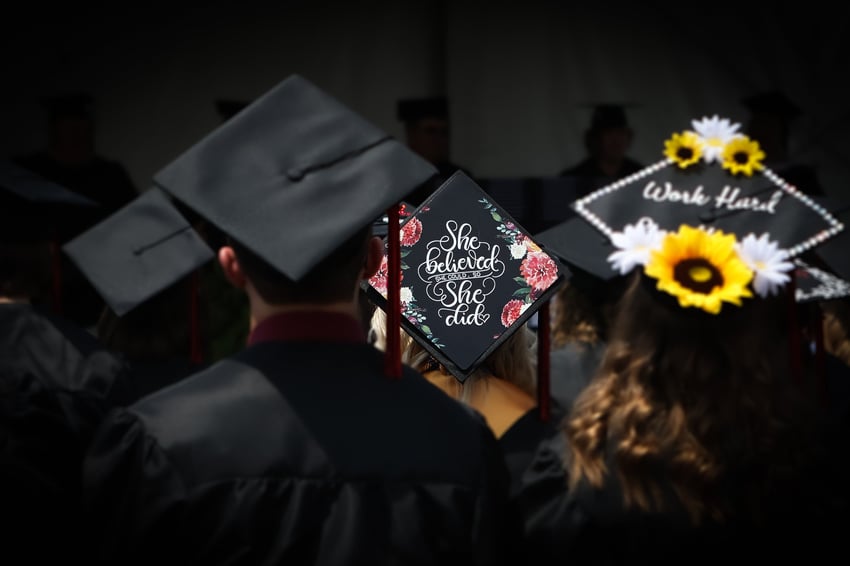 (Words of encouragement decorated on graduate's cap - "She believed she could, so she did.")