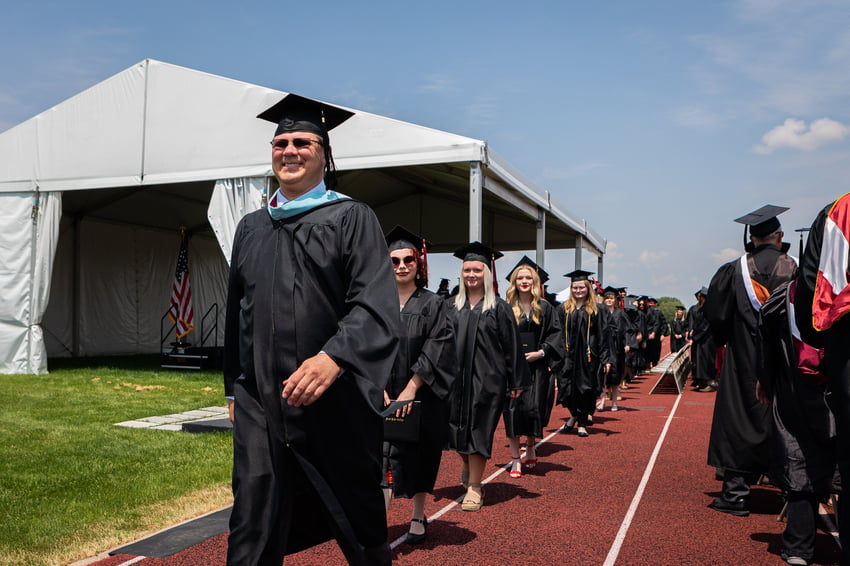 (Associate VP of Academic & Student Services, Buster Leeck, leads the recessional of the 2022 Rend Lake College graduates.)