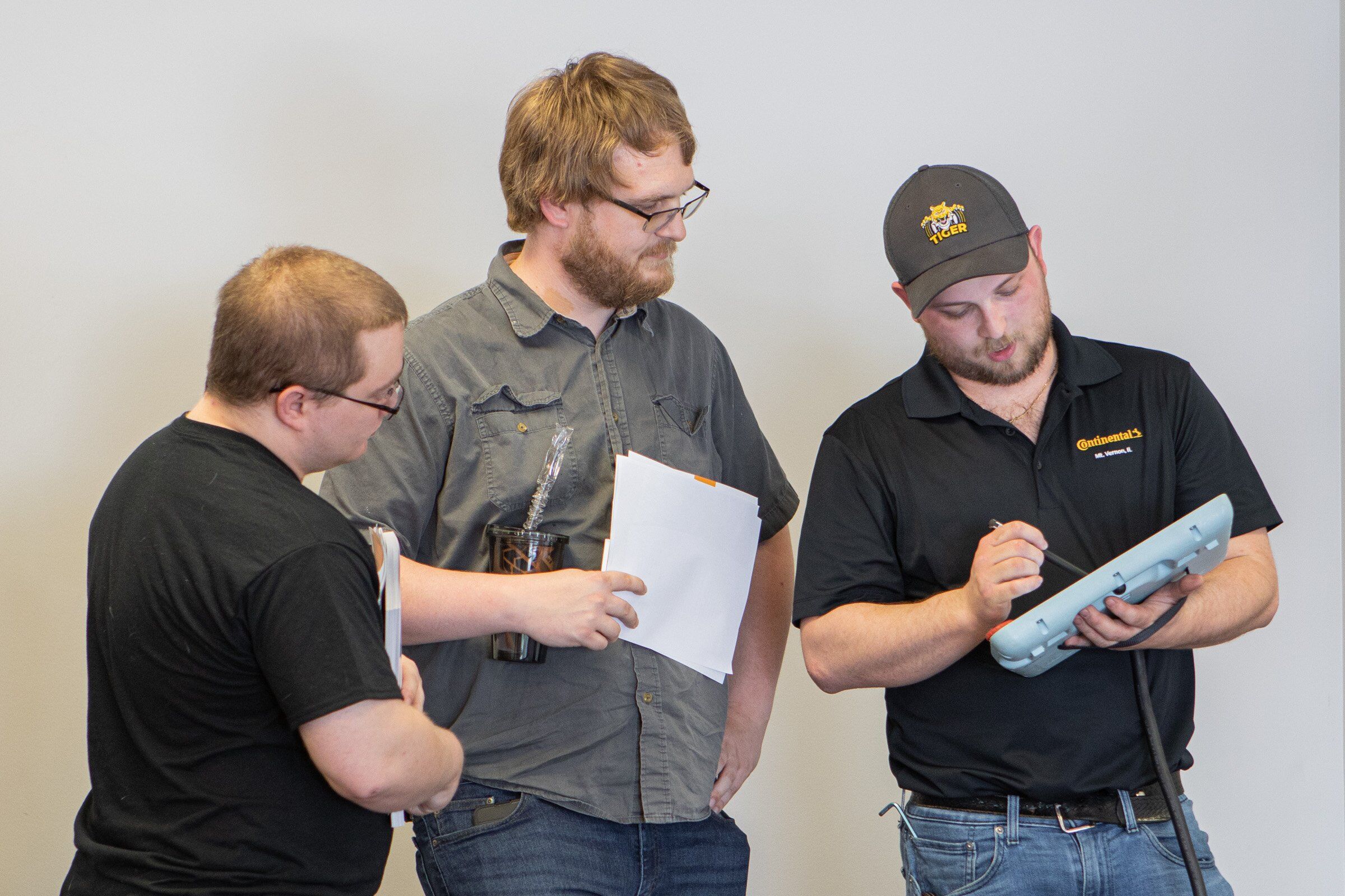 (L-R) Shane Hiatt (Mt. Vernon) and Alex Bronson (Dix) learn about the robot's controller from Continental Tire Systems Specialist Aubreylee Jones.