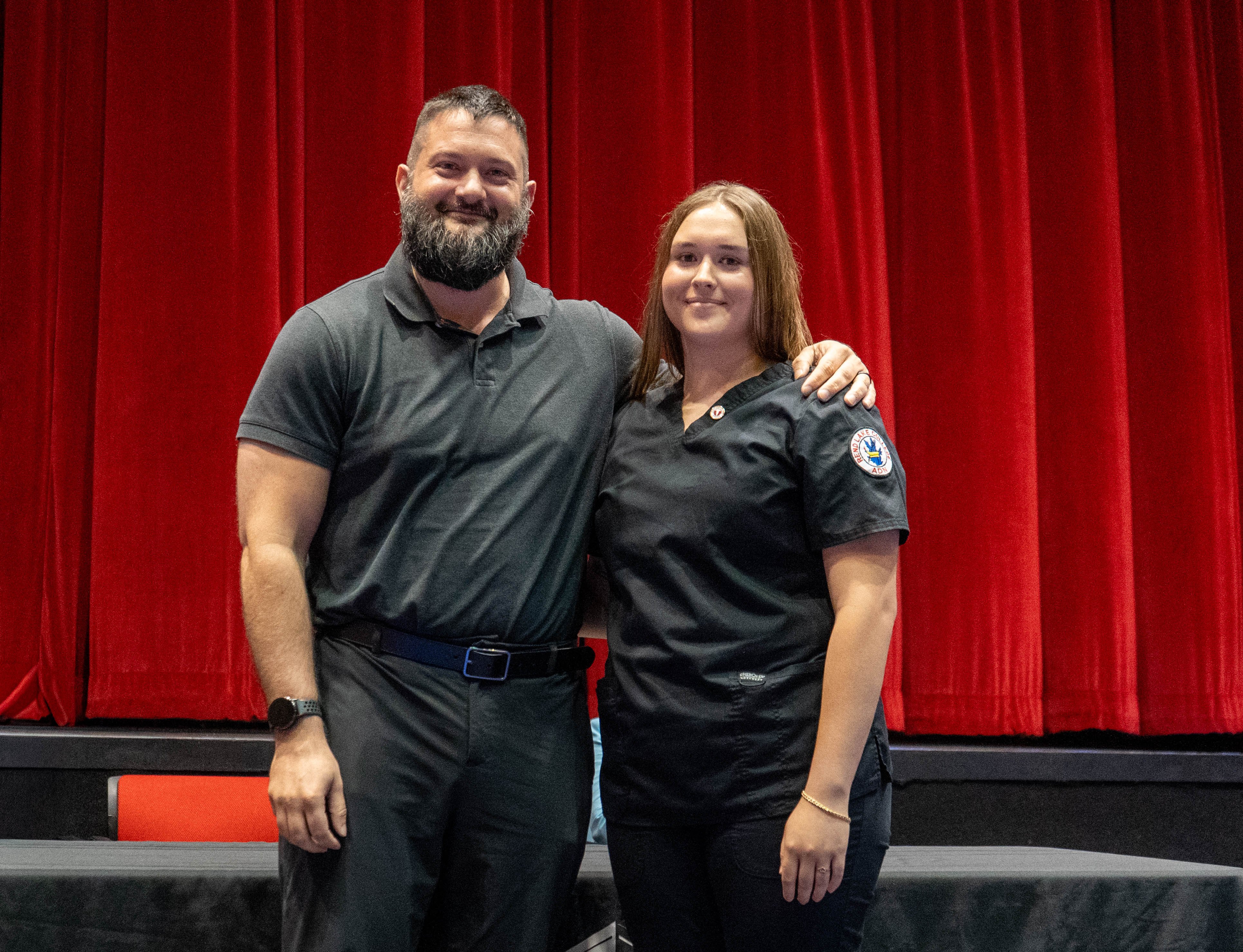 Annie Wilkerson (right) receives pin from Zach Holstetter (left)