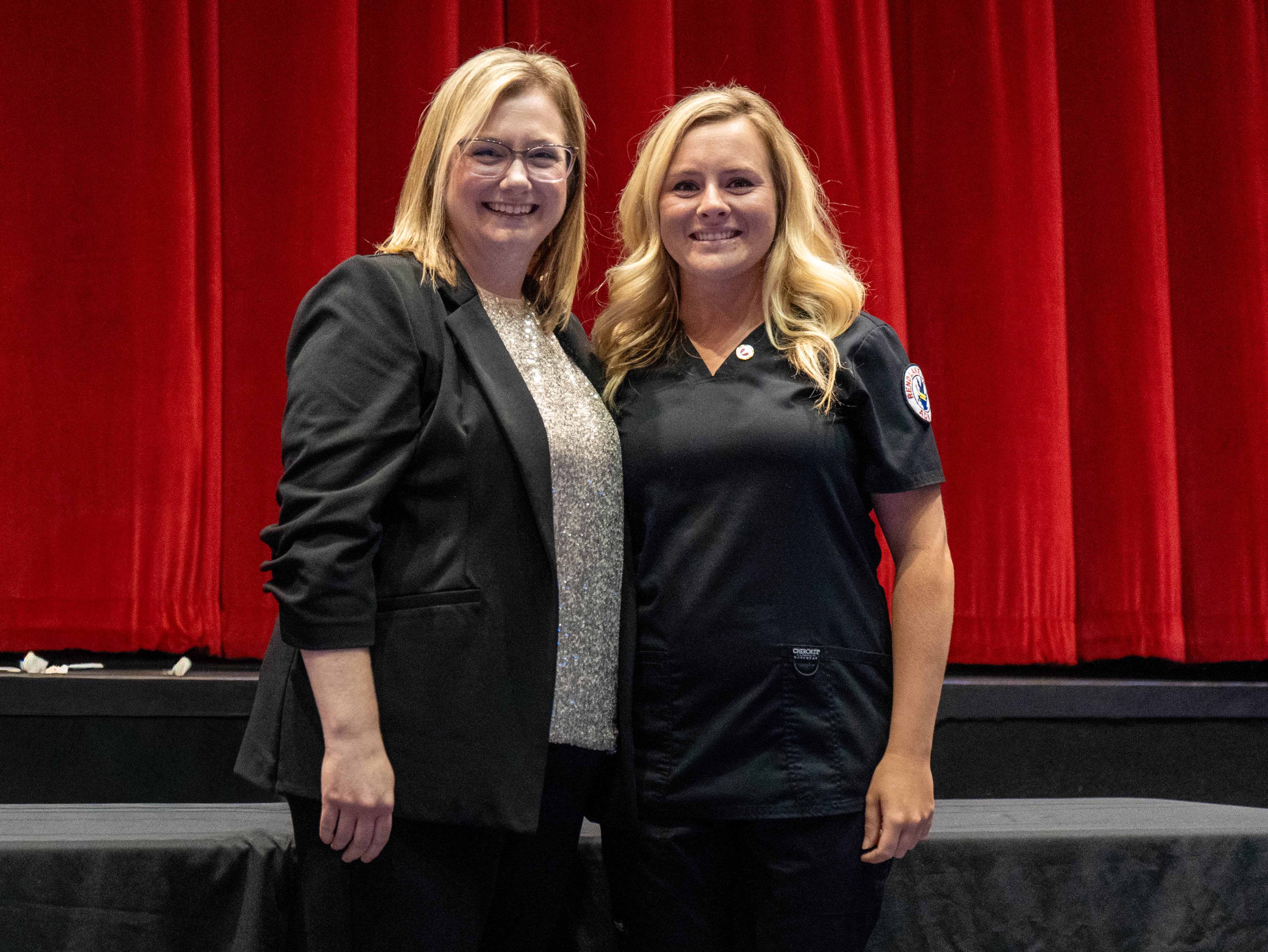 Danyelle Hess (right) receives pin from Sarah Hopfinger (left)