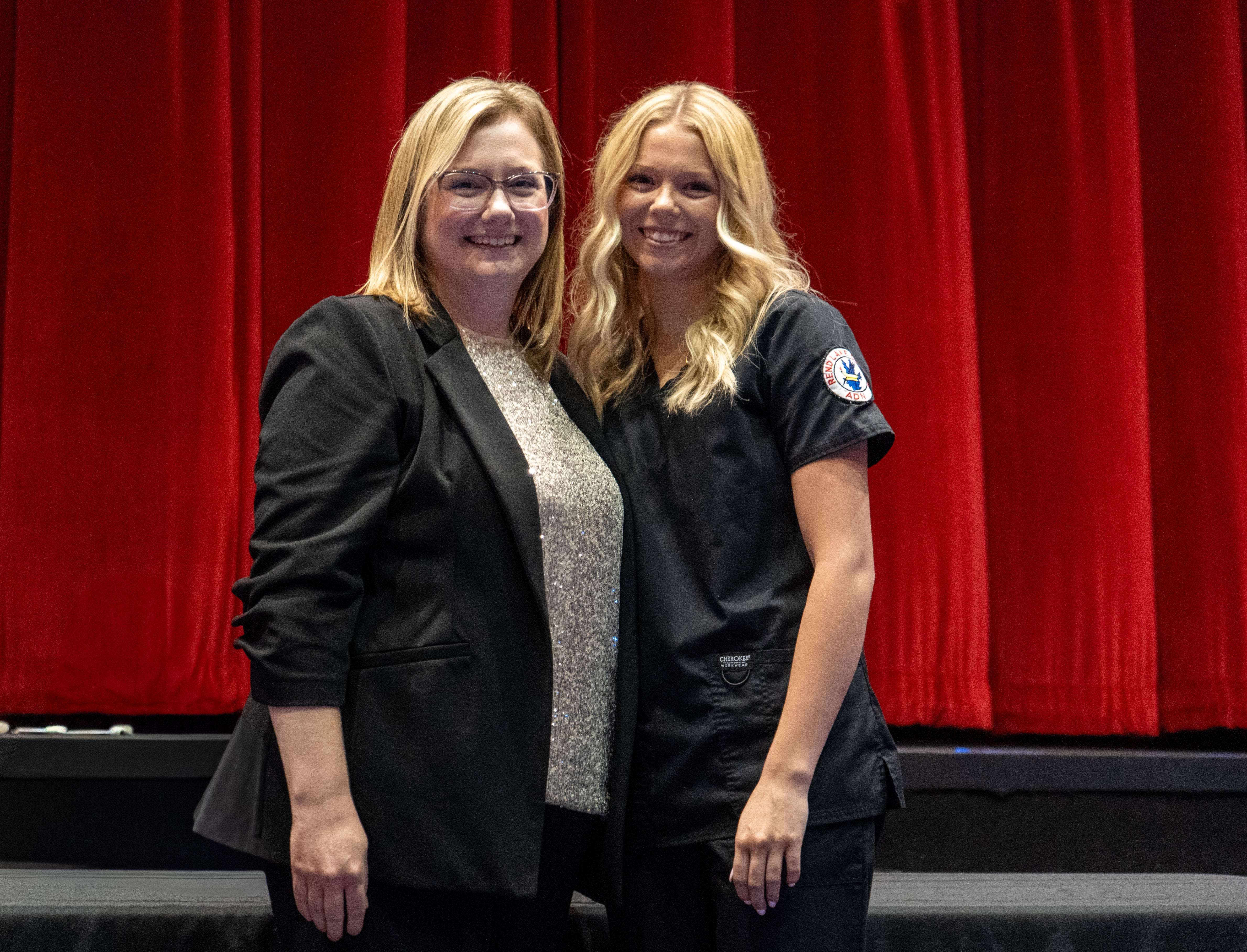 Gemma Kinkade (right) receives pin from Sarah Hopfinger (left)
