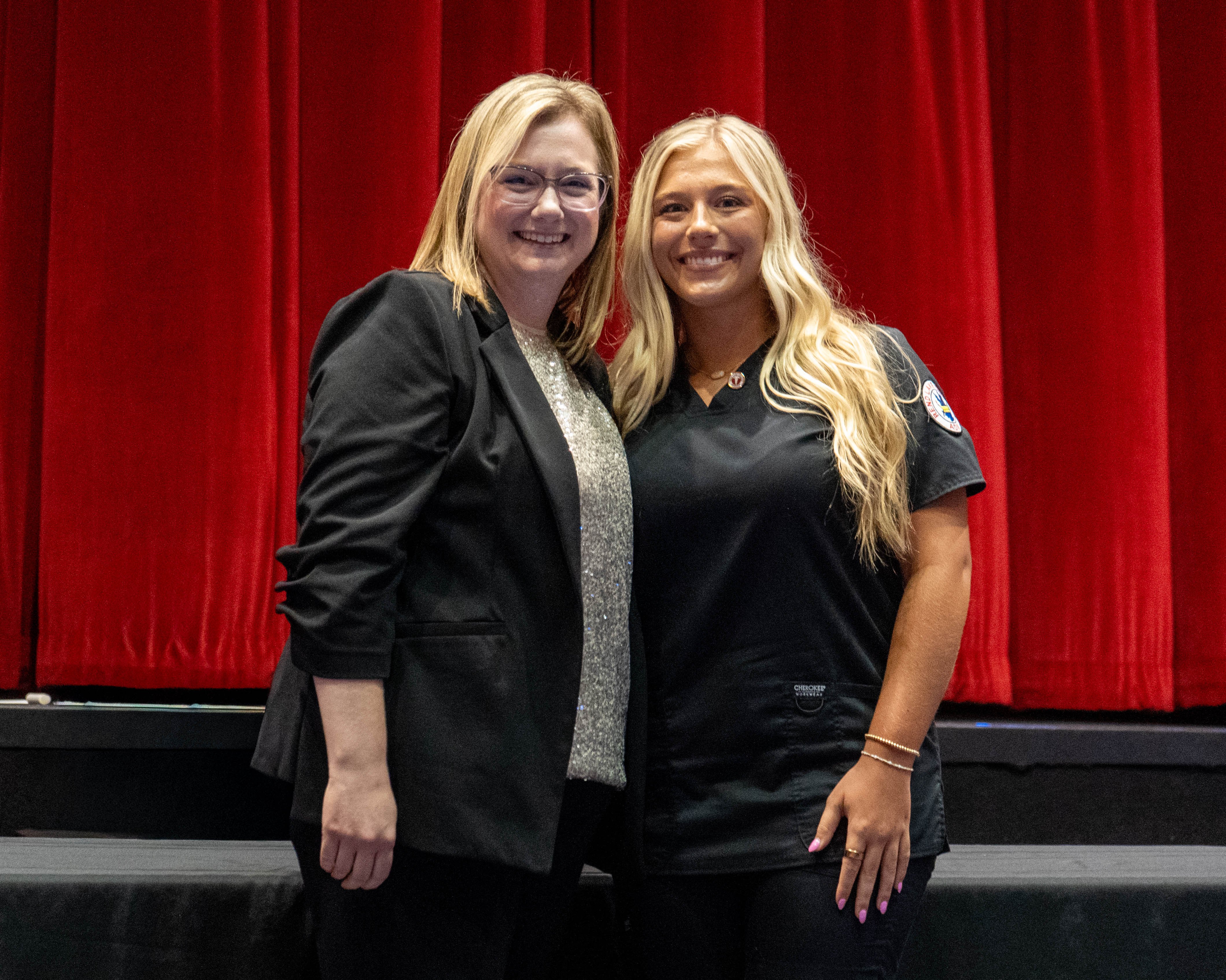 Josie Greenwalt (right) receives pin from Sarah Hopfinger (left)