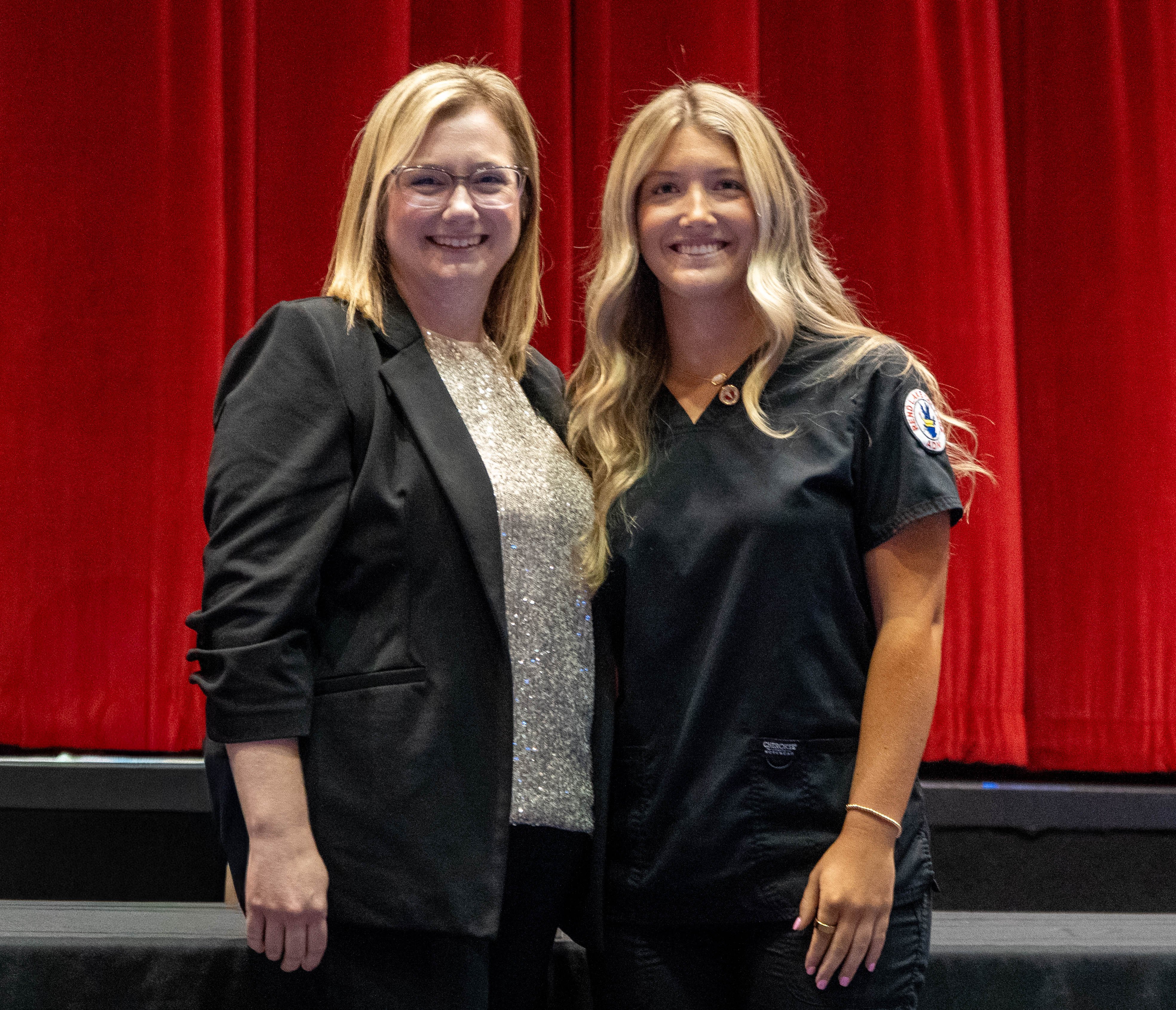 Mackenzie Burke (right) receives pin from Sarah Hopfinger (left)