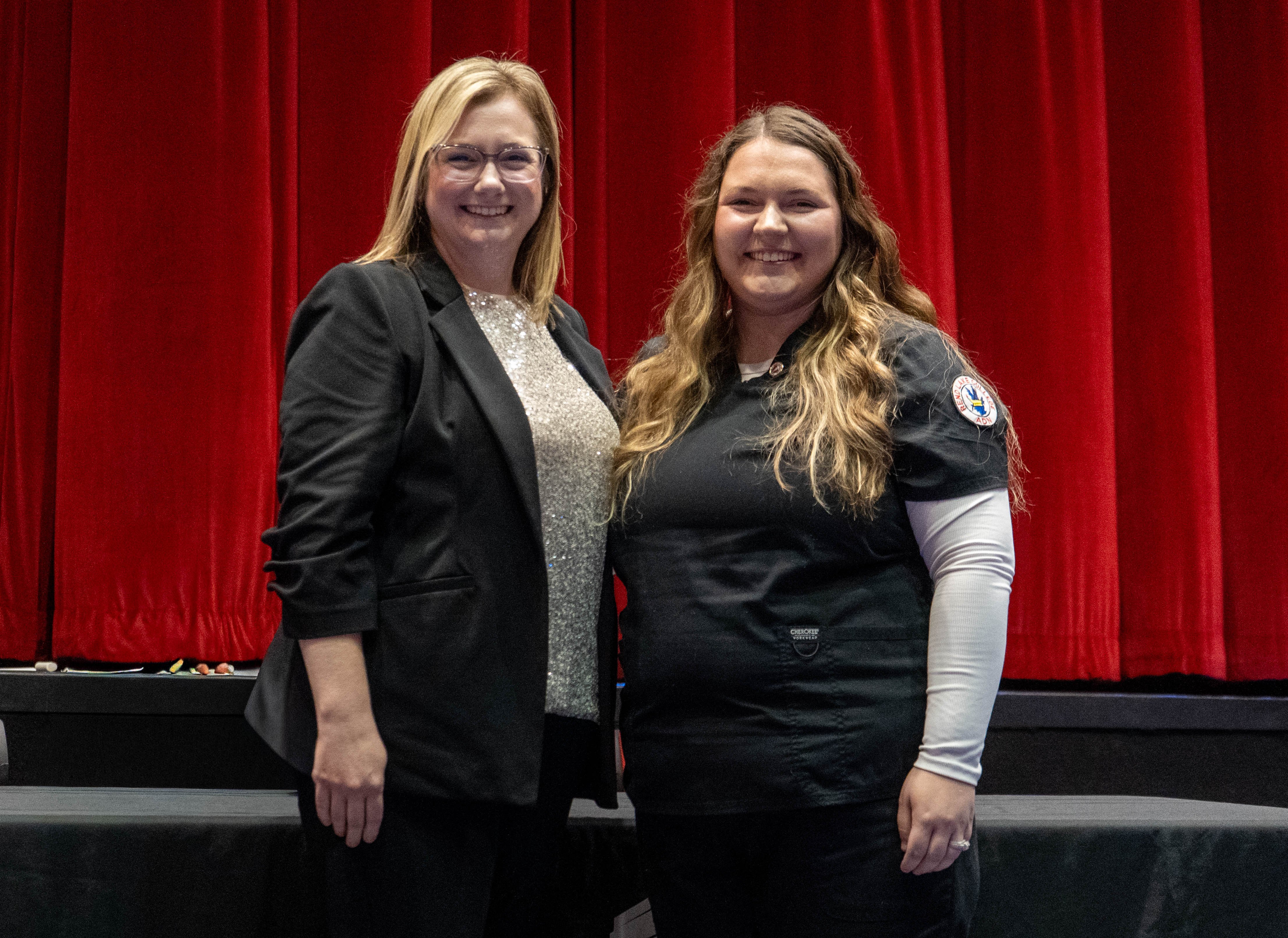 Sarah Buckman (right) receives pin from Sarah Hopfinger (left)