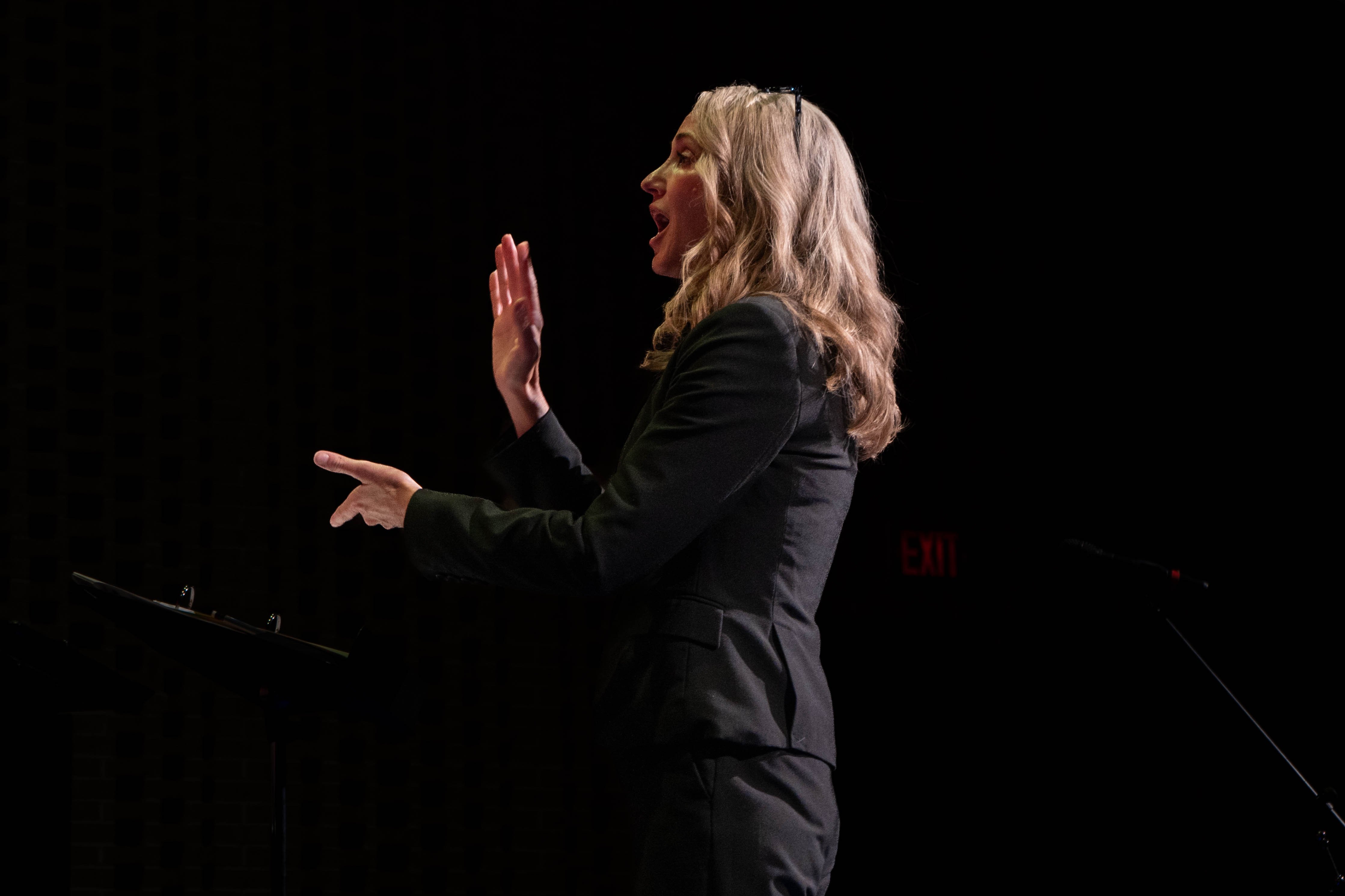  RLC music professor Sara Alstat-Sanders conducts with expressive hand gestures during the 2026 Spring Concert: Chiaroscuro.