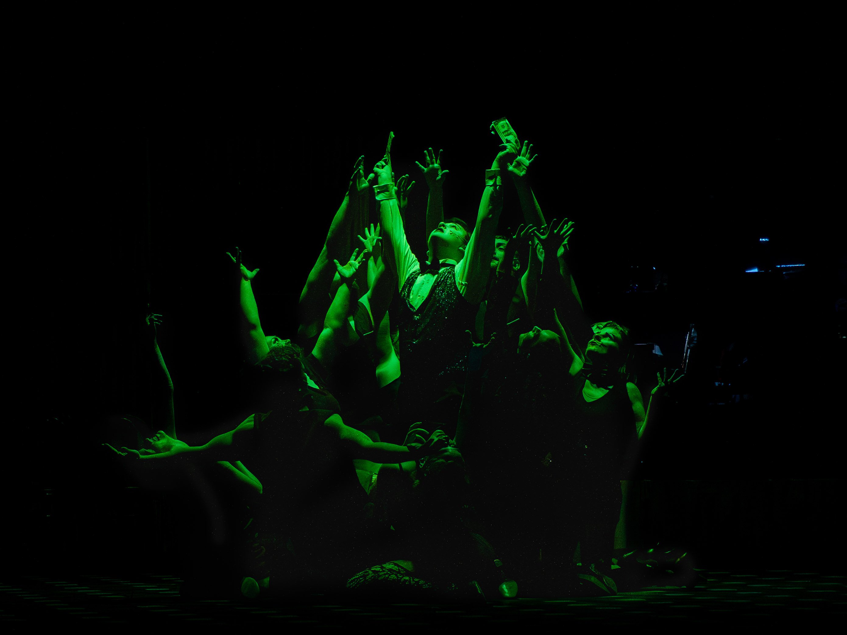 Actors hit a final pose in a scene with green light enveloping them.