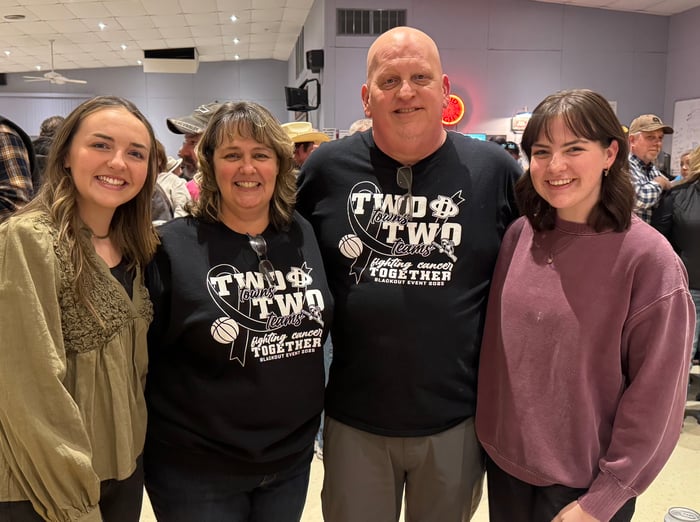 The Stacey family pose for a photo at a black out for cancer event in 2025.