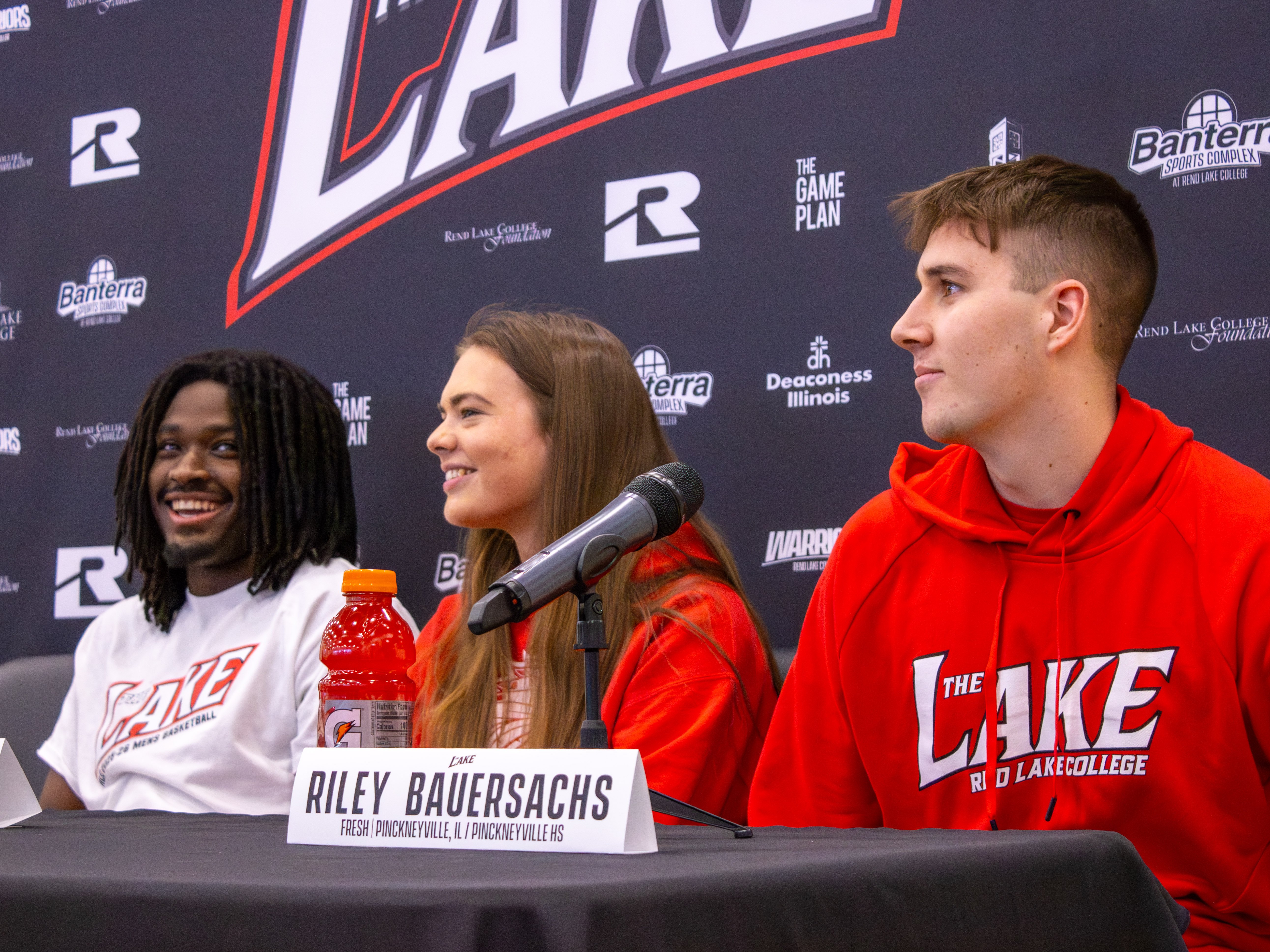 During the Banterra Sports Complex ribbon-cutting, a panel discusses the renovated gym in front of a "The Lake" backdrop. From left to right: Elijah Edosa, Ramsey Haggard, and Riley Bauersachs.