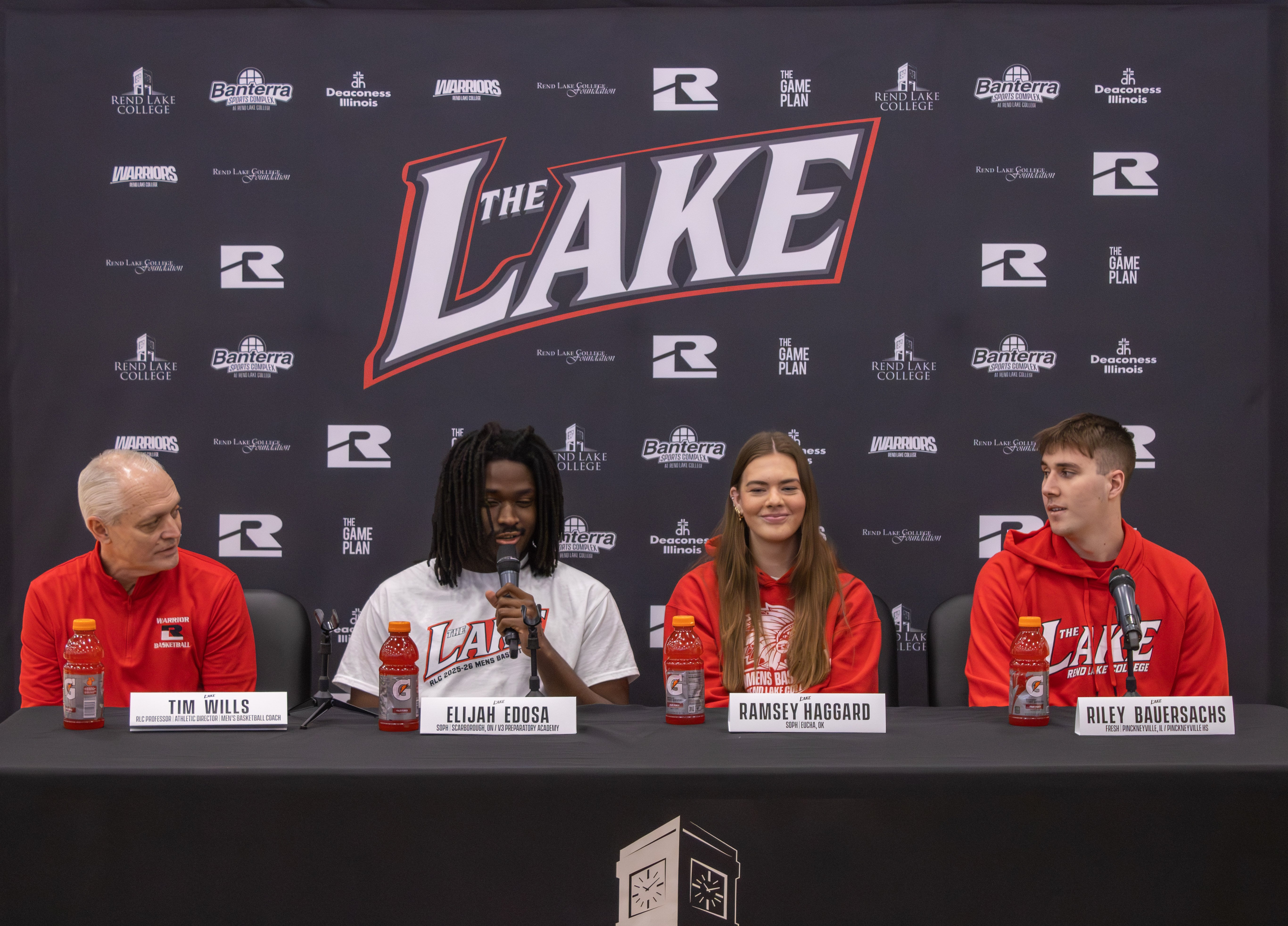 During the Banterra Sports Complex ribbon-cutting, a panel discusses the renovated gym in front of a "The Lake" backdrop. From left to right: Head Coach Tim Wills, and student-athletes Elijah Edosa, Ramsey Haggard, and Riley Bauersachs.